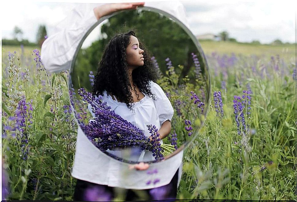 Woman holding a mirror in a lavender field.