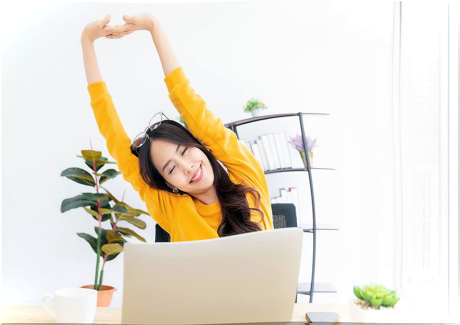 Girl stretching in front of laptop.