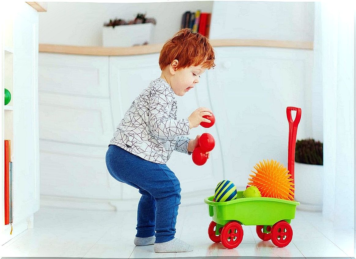 Boy picking up toys