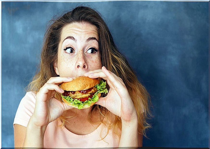 Girl eating a hamburger after exercising