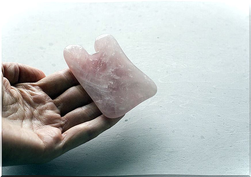 Hand holding rose quartz.